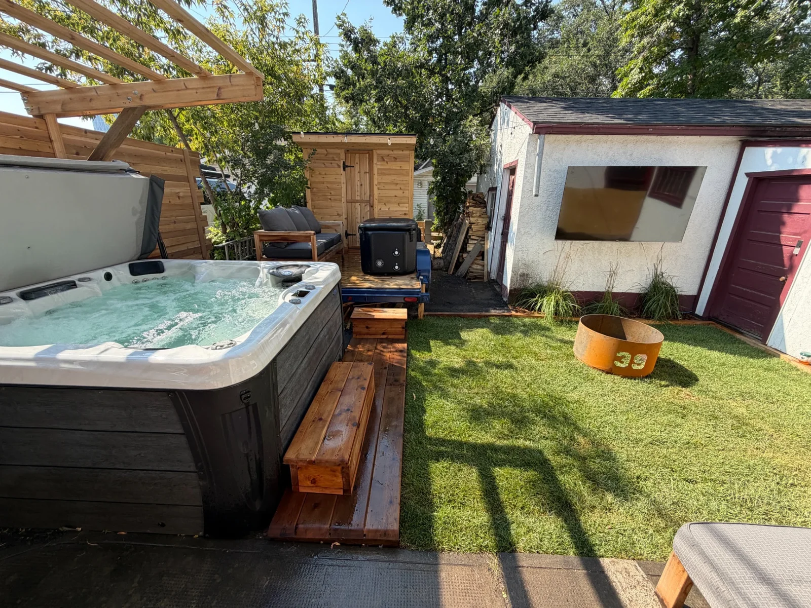 Merlot House backyard with hot tub, sauna, lawn and unlit fire pit