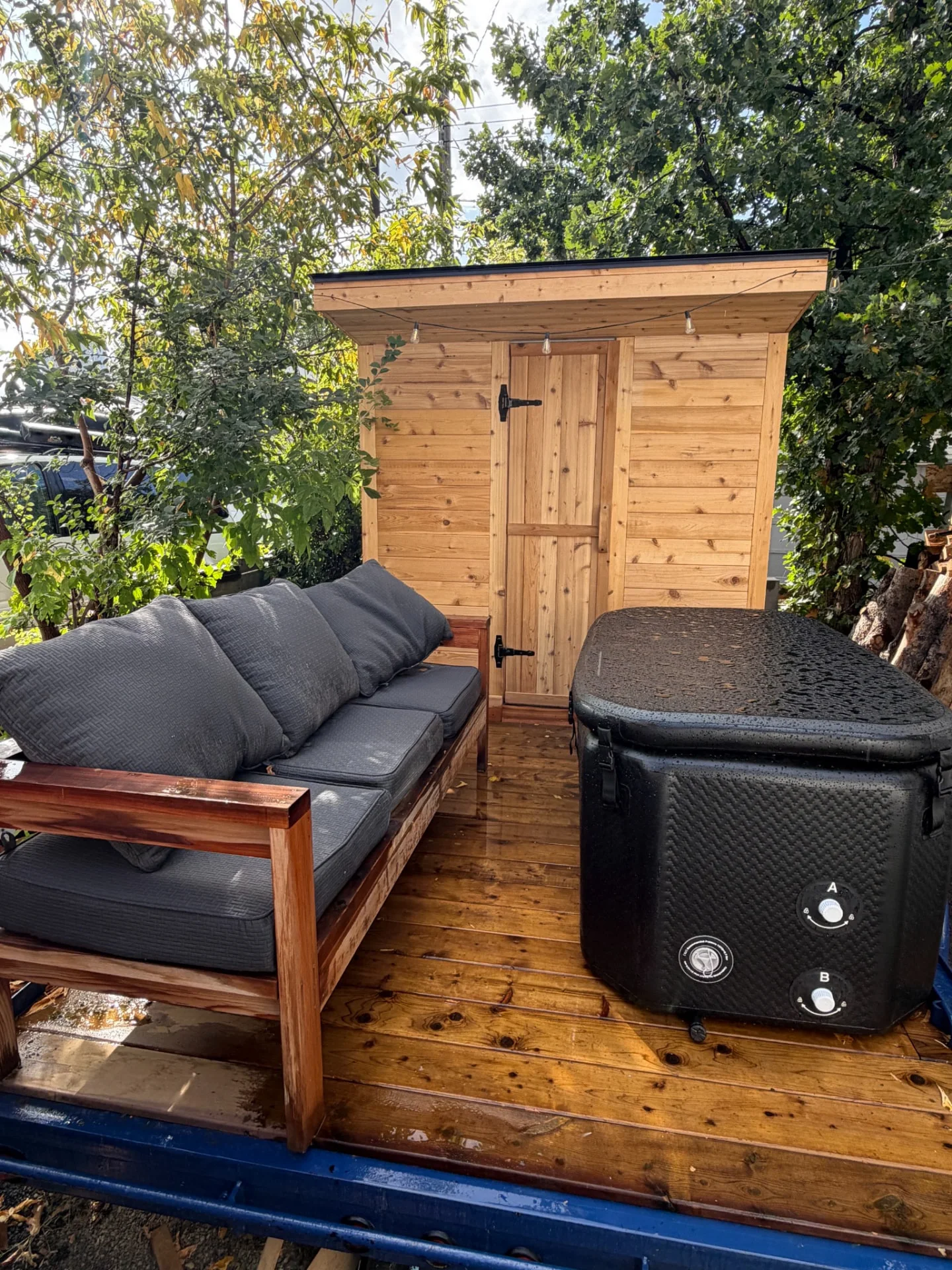 Cedar sauna, covered cold plunge and cushioned lounge on the Merlot House backyard deck